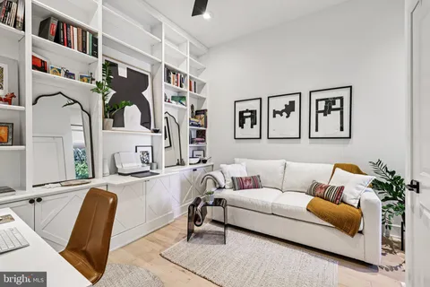 a living room with furniture and painting on the wall
