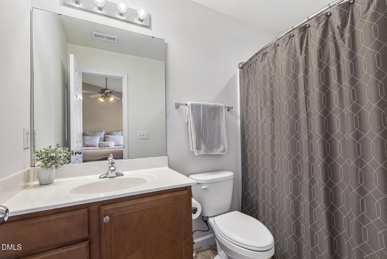 2131 Piney Brook Road, Unit 102 Raleigh, NC 27614 - Photo 18 of 23 a bathroom with a sink a toilet a mirror and shower curtain