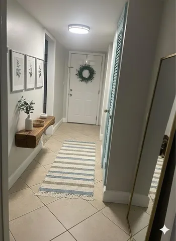 a view of a hallway to a livingroom with furniture and stairs