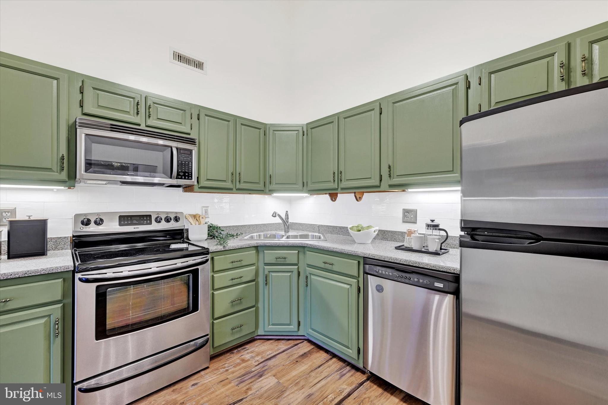 22 Rain Flower Path, Unit 301 Sparks Glencoe, MD 21152 - Photo 12 of 21 a kitchen with stainless steel appliances a stove sink and microwave