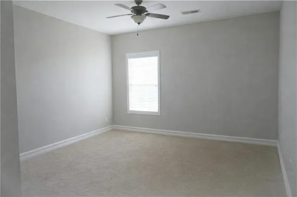 an empty room with a window and a fan