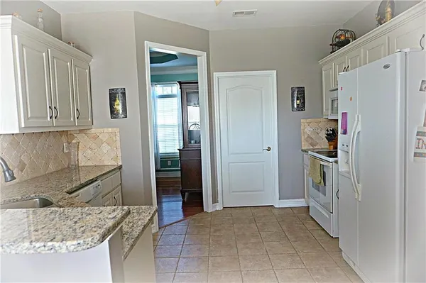 a kitchen with stainless steel appliances granite countertop a refrigerator and a sink