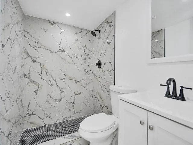 a bathroom with a toilet sink and shower