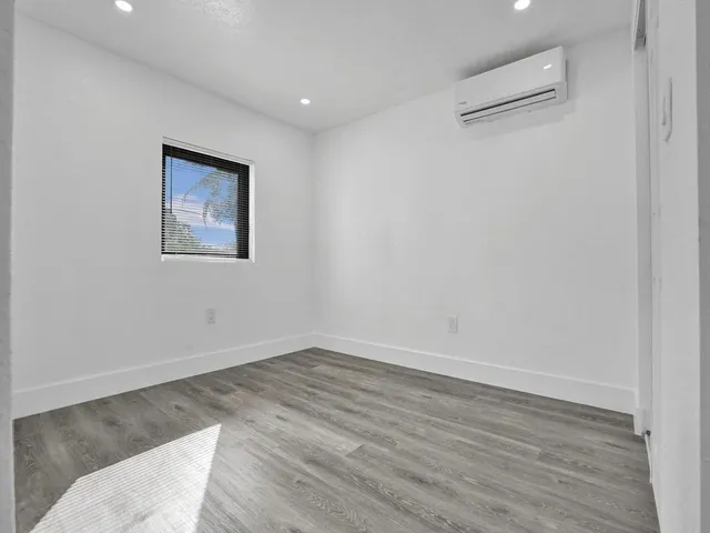 a view of a room with wooden floor and white walls