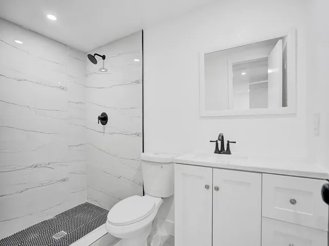 a bathroom with a toilet a sink and shower