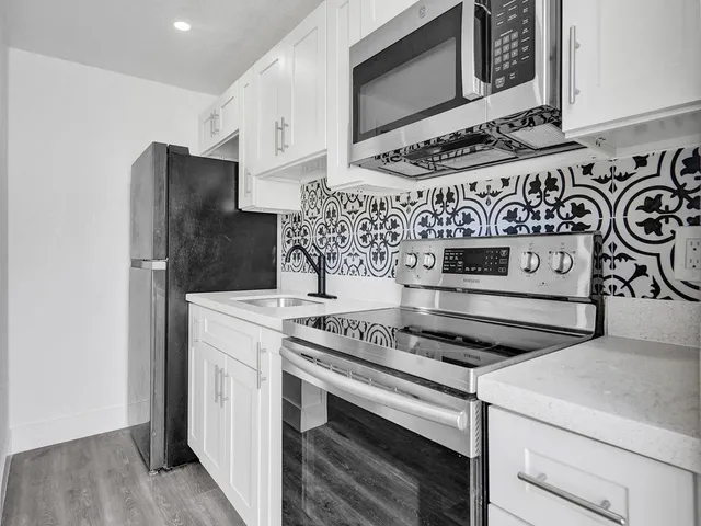 a kitchen with stainless steel appliances granite countertop a stove and a microwave