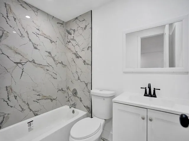 a bathroom with a toilet sink shower and mirror