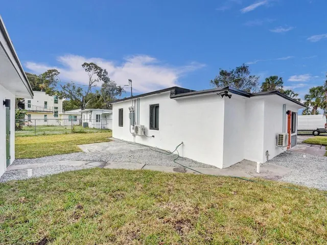 a view of a house with backyard and sitting area