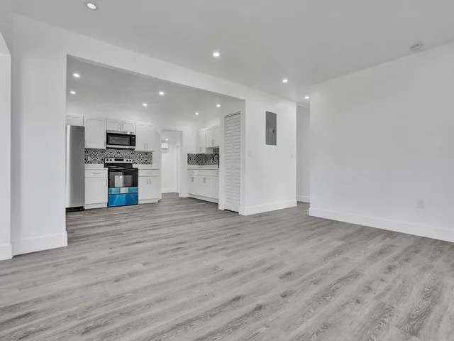 a view of kitchen with cabinets appliances and wooden floor