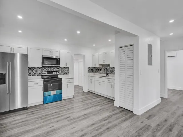 a kitchen with a refrigerator and a stove top oven