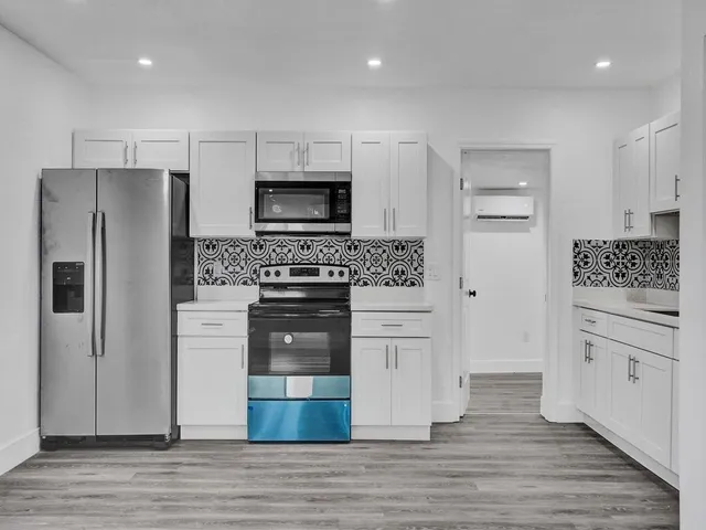 a kitchen with white cabinets and stainless steel appliances