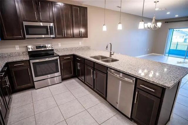 a kitchen with stainless steel appliances granite countertop a sink stove and microwave