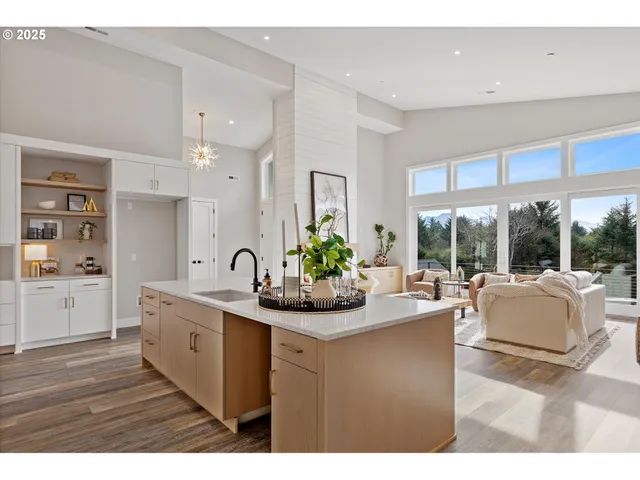 a kitchen with stainless steel appliances granite countertop a sink a stove a dining table and chairs