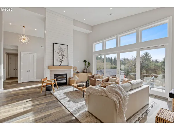 a living room with furniture a fireplace and a floor to ceiling window
