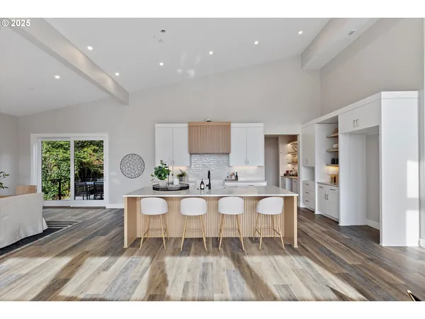 a living room with furniture a wooden floor and a large window
