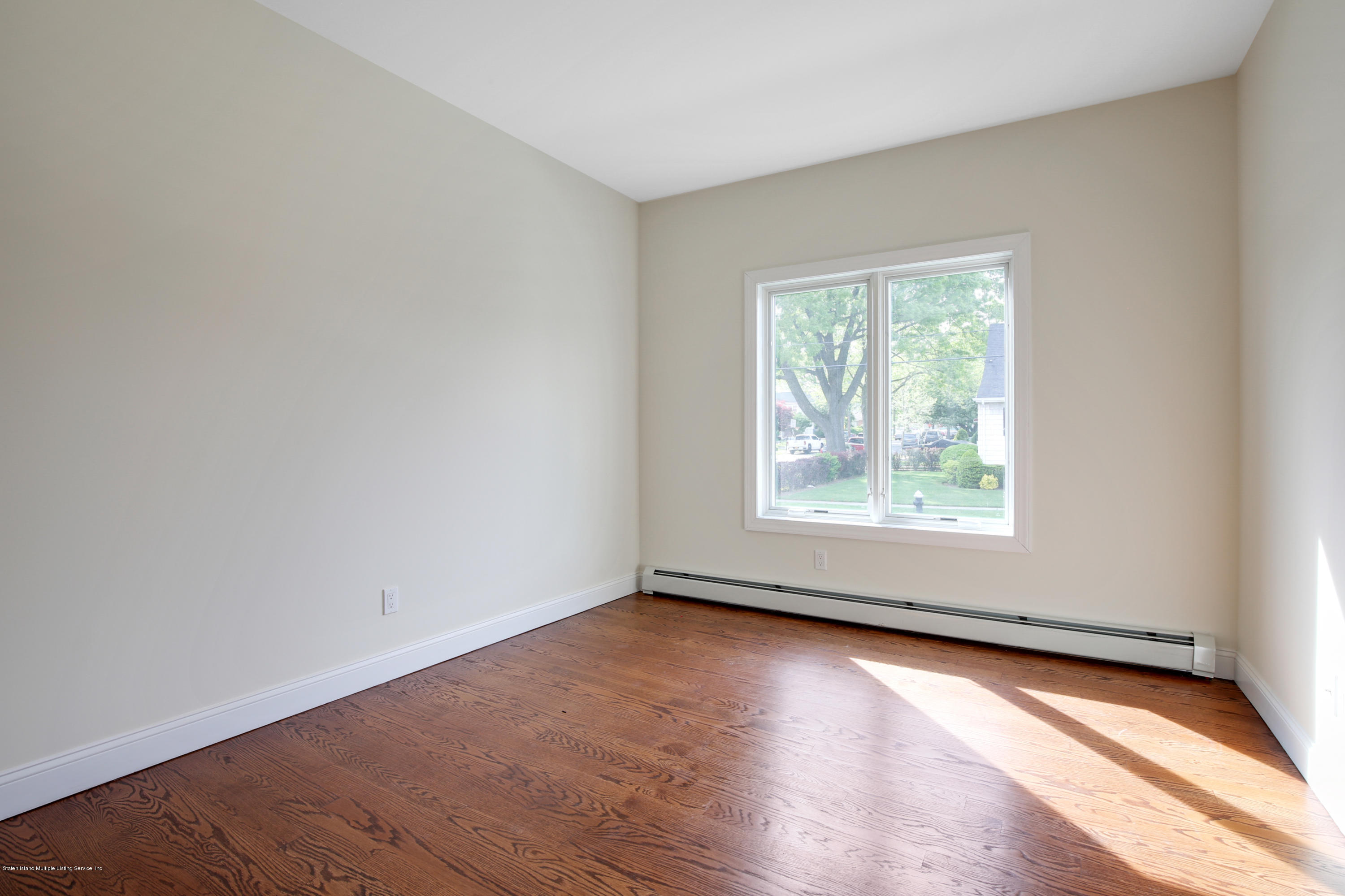 232 8 Street Staten Island, NY 10306 - Photo 18 of 25 an empty room with wooden floor and windows