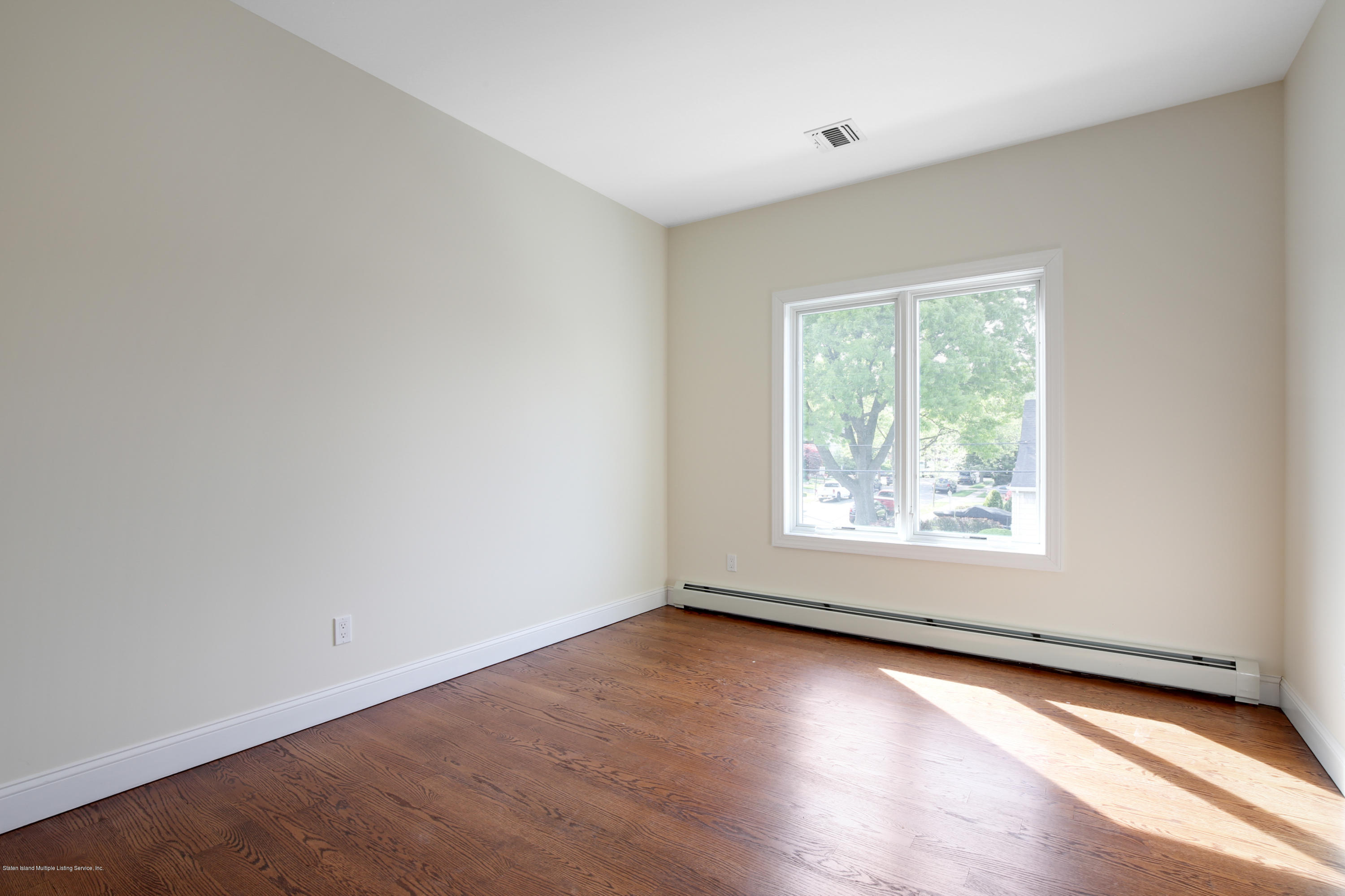 232 8 Street Staten Island, NY 10306 - Photo 9 of 25 an empty room with wooden floor and windows