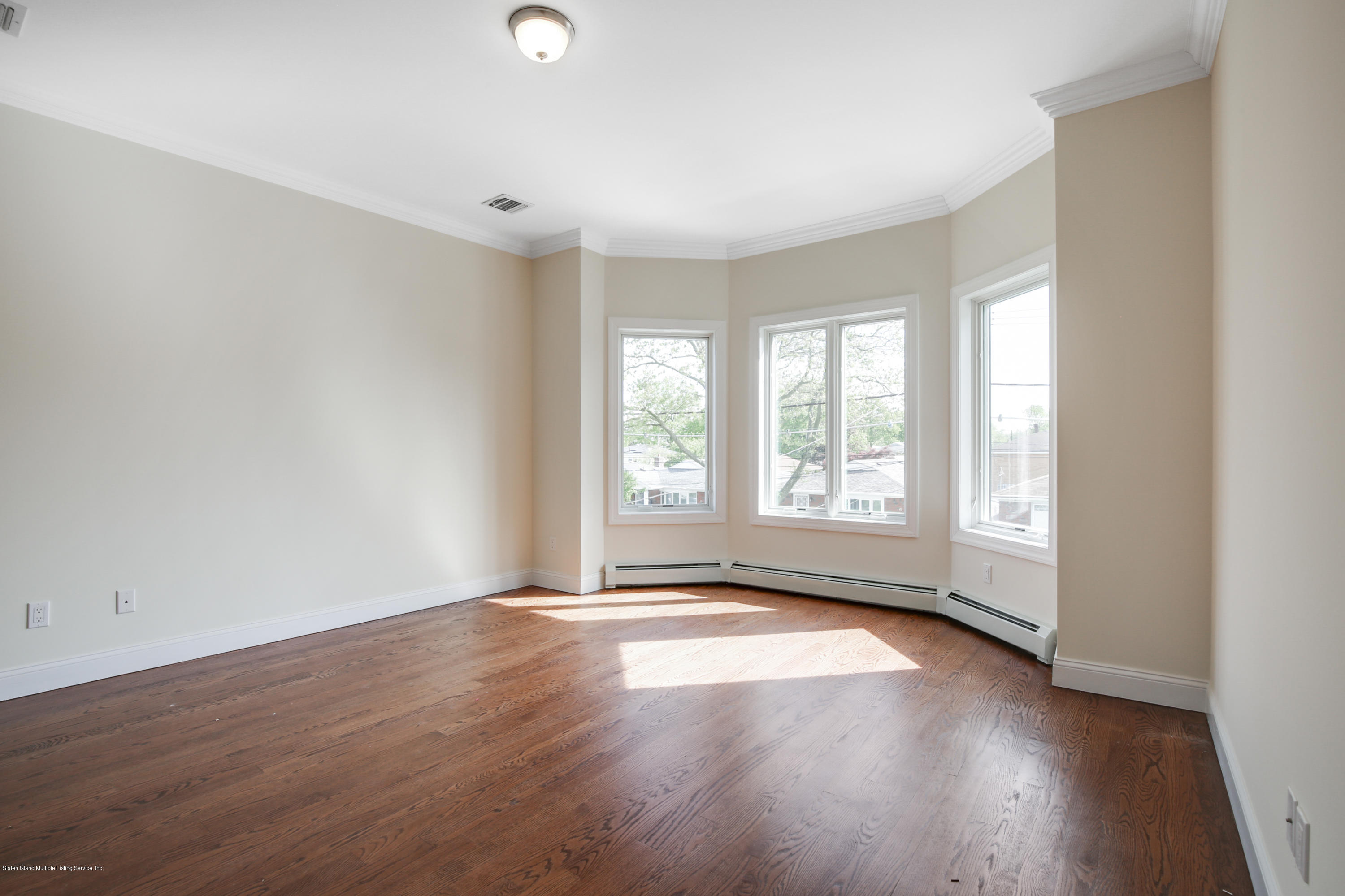 232 8 Street Staten Island, NY 10306 - Photo 10 of 25 a view of an empty room with wooden floor and a window