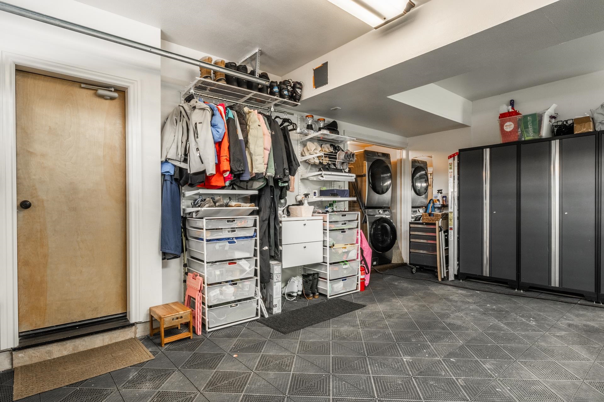 1787 Old Mammoth Road, Unit 2 Mammoth Lakes, CA 93546 - Photo 22 of 29 Garage interior featuring textured tile flooring, recessed lighting, built-in storage shelving, and stacked washer and dryer units