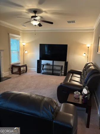 a living room with furniture a ceiling fan and a window