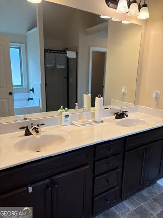 a bathroom with double vanity sinks and a mirror