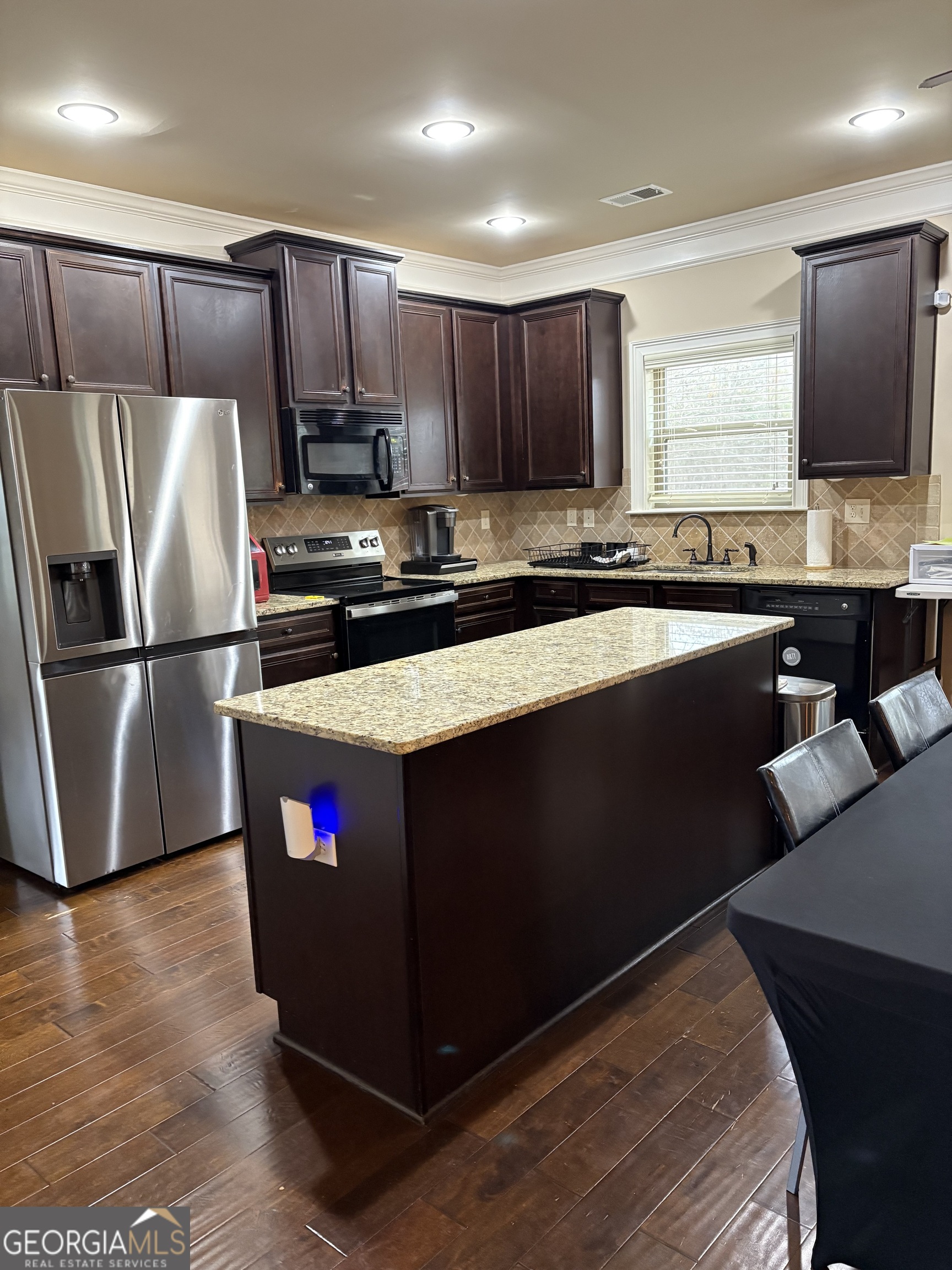 208 Deodar Lane Hampton, GA 30228 - Photo 8 of 28 a kitchen with stainless steel appliances granite countertop a refrigerator a sink a stove a microwave and wooden floor