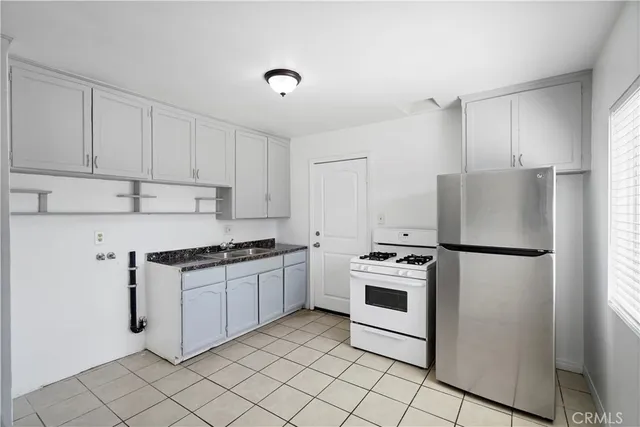 a kitchen with granite countertop white cabinets and white stove