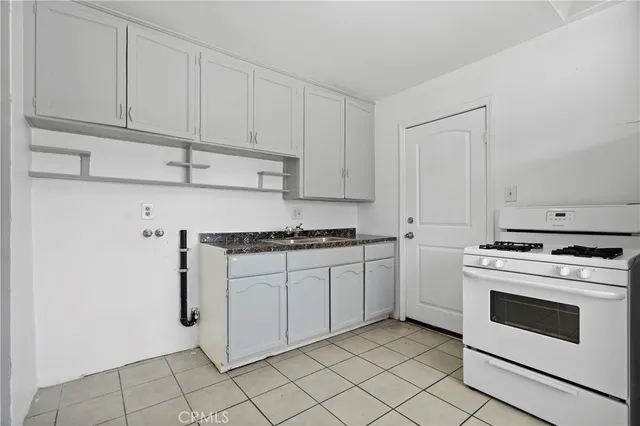 a view of a kitchen with refrigerator and white cabinets
