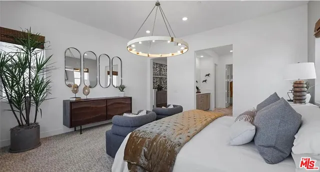 a bedroom with bed a chandelier and a bookshelf with wooden floor