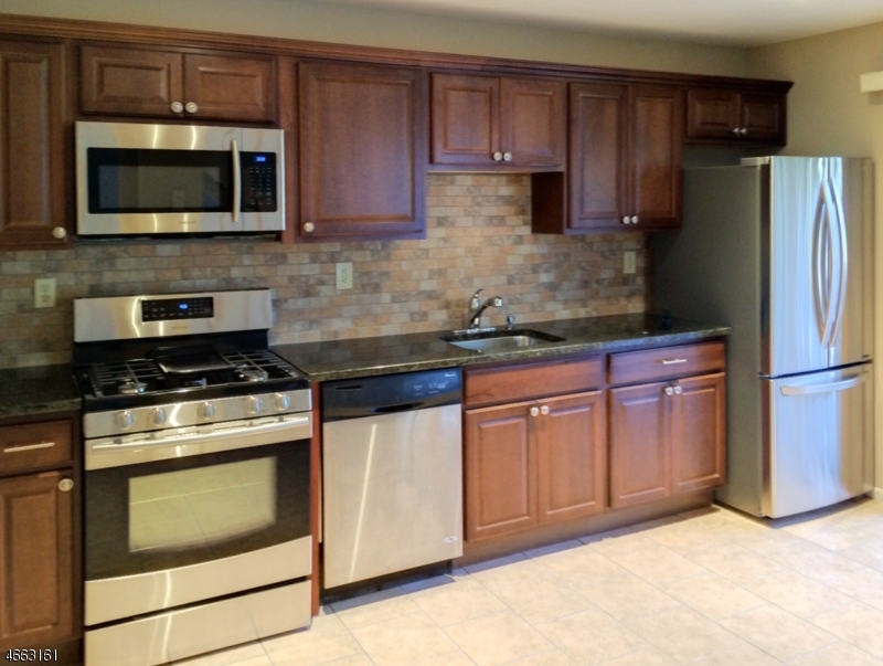 64 Sycamore Court Bernards, NJ 07920 - Photo 5 of 27 a kitchen with granite countertop wooden cabinets stainless steel appliances and a counter space