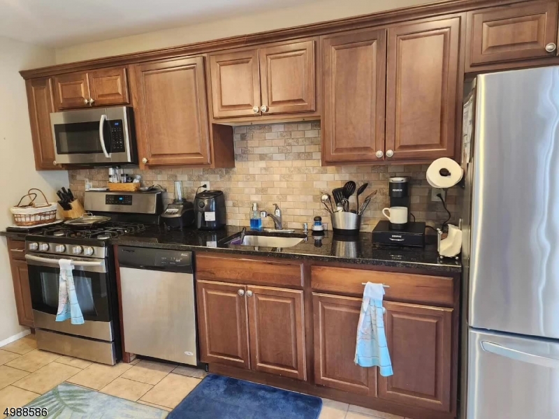 64 Sycamore Court Bernards, NJ 07920 - Photo 8 of 27 a kitchen with stainless steel appliances granite countertop a stove a sink and a refrigerator