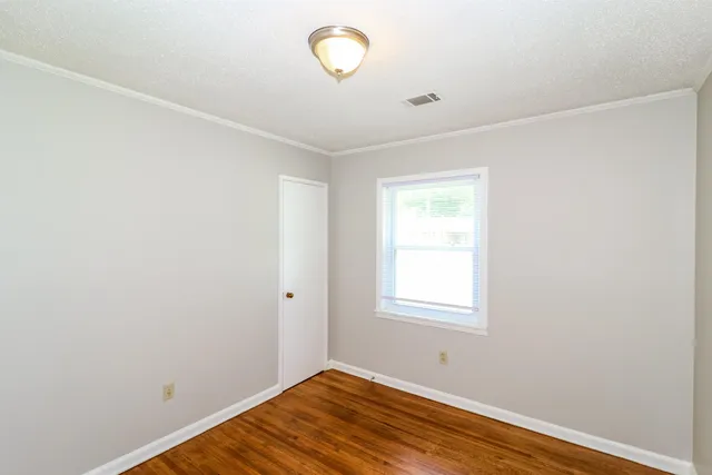 a view of a room with wooden floor and fan