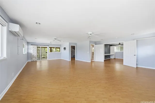 a view of empty room with kitchen and window
