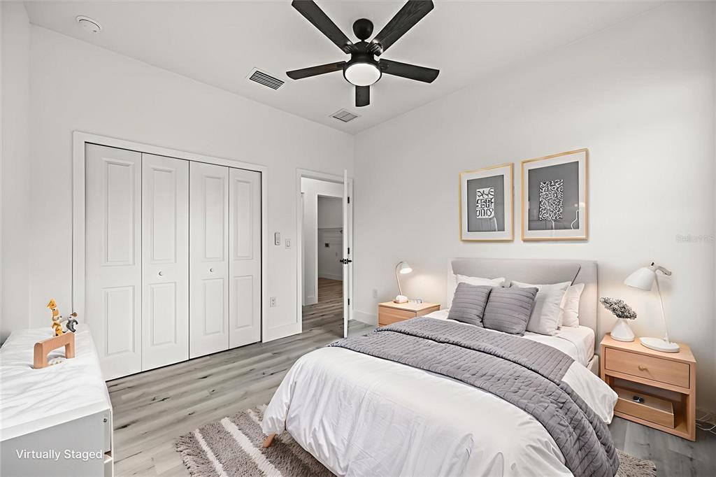 2798 Gainesville Road Southeast Palm Bay, FL 32909 - Photo 15 of 35 a bedroom with a large bed and a chandelier