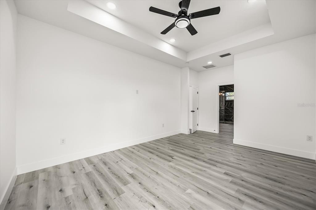 2798 Gainesville Road Southeast Palm Bay, FL 32909 - Photo 24 of 35 an empty room with wooden floor and windows