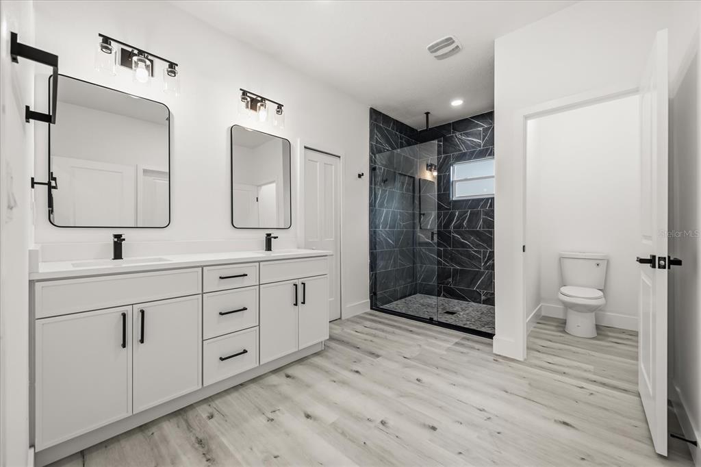 2798 Gainesville Road Southeast Palm Bay, FL 32909 - Photo 28 of 35 a bathroom with a double vanity sink mirror and shower