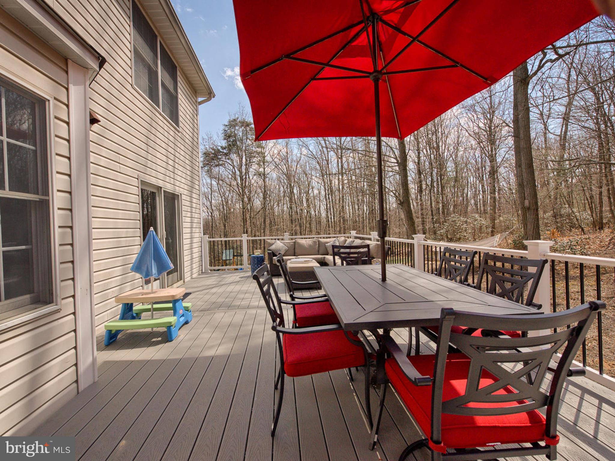 3364 Basford Road Frederick, MD 21703 - Photo 26 of 30 a view of a patio with table and chairs under an umbrella with wooden floor