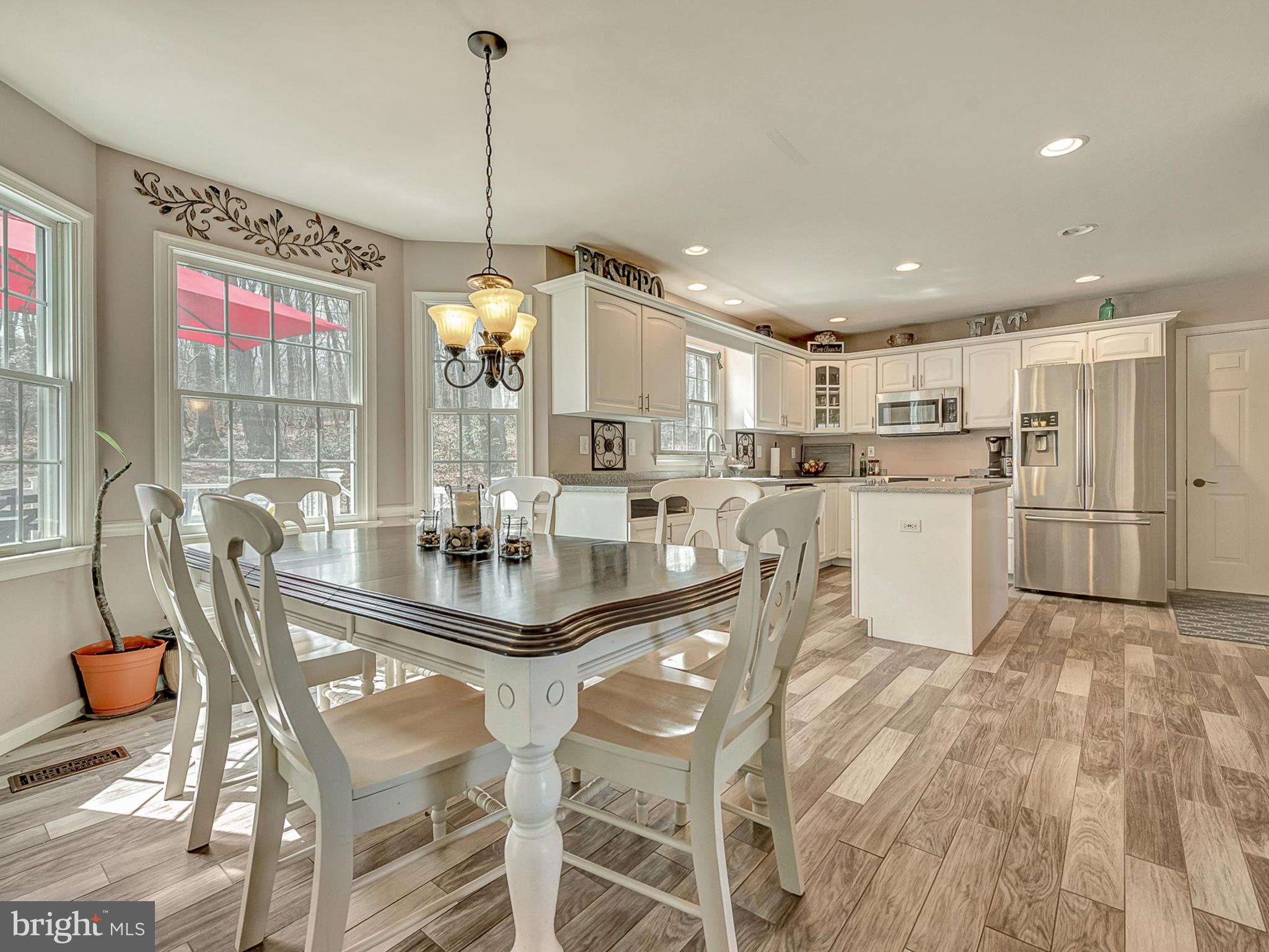 3364 Basford Road Frederick, MD 21703 - Photo 8 of 30 a kitchen with stainless steel appliances kitchen island granite countertop a dining table chairs and white cabinets