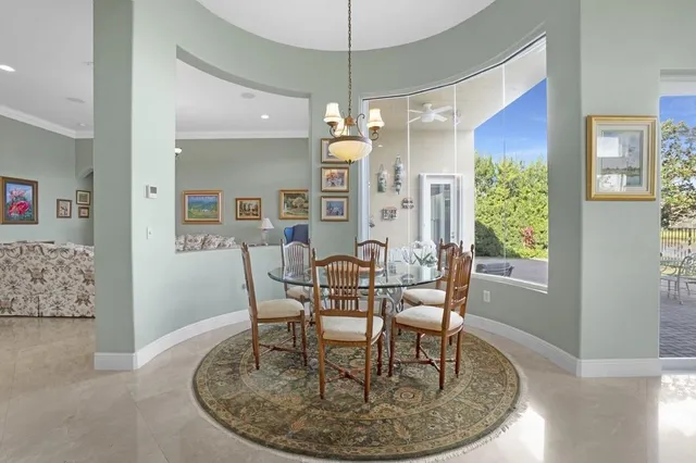 a living room with furniture a chandelier and a dining table