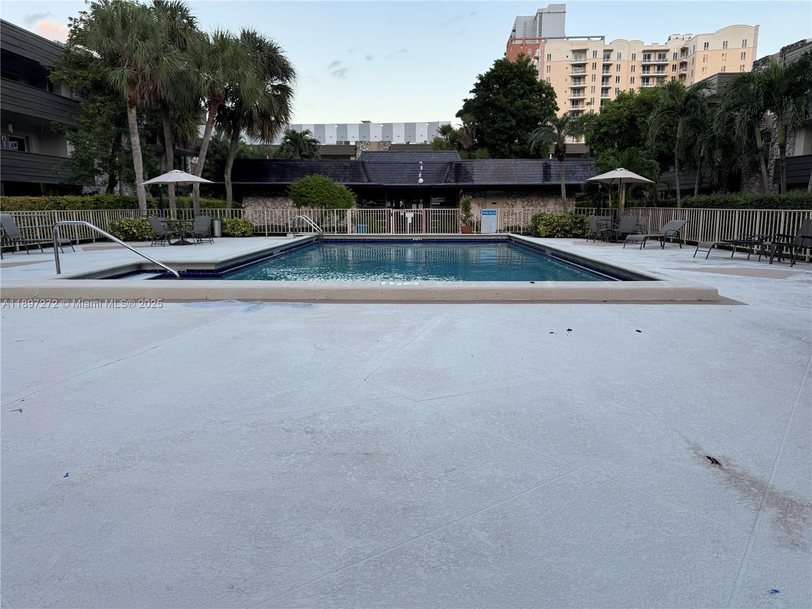8315 Southwest 72nd Avenue, Unit 101B Miami, FL 33143 - Photo 14 of 18 a swimming pool with outdoor seating and yard
