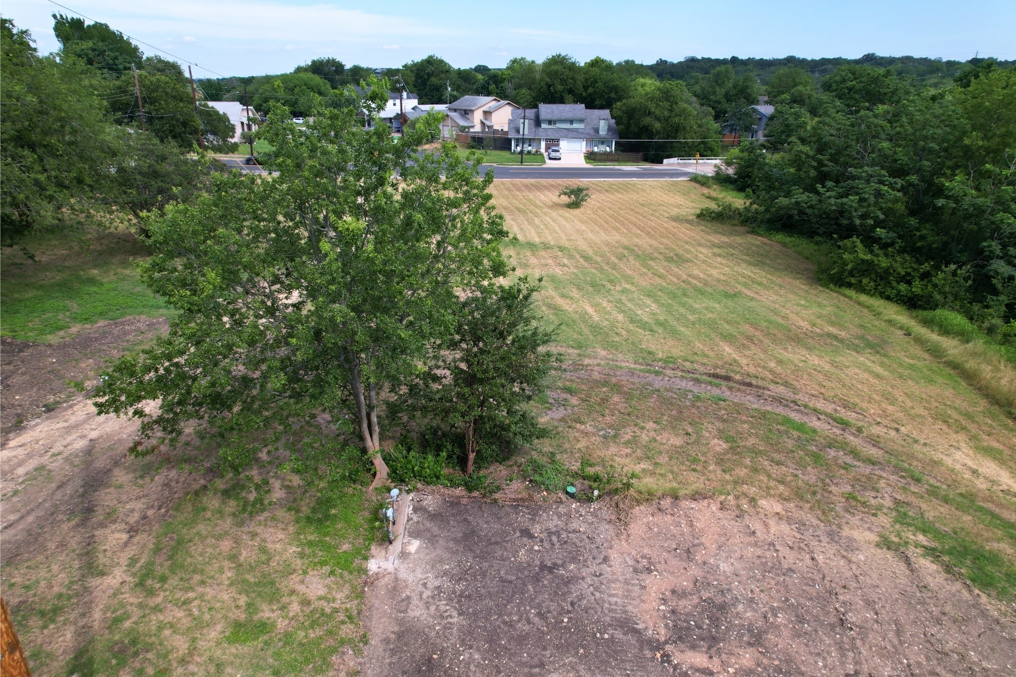 2610-2606 Metcalfe Road Austin, TX 78741 - Photo 20 of 20 A spacious, buildable lot awaits your vision, bordered by verdant trees and mature landscaping.