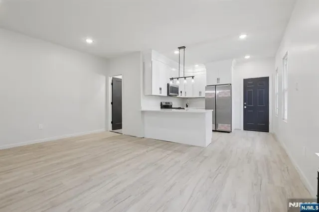 a kitchen with stainless steel appliances kitchen island a refrigerator sink and cabinets