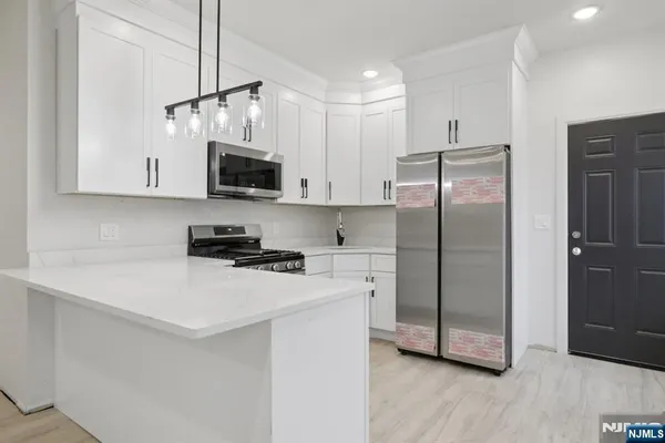 a kitchen with stainless steel appliances a refrigerator sink and microwave