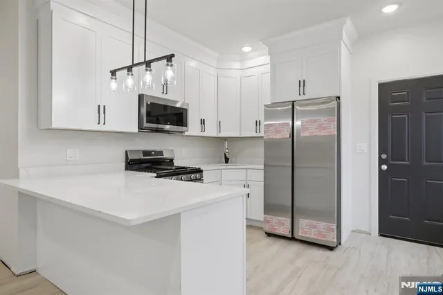 a kitchen with stainless steel appliances a refrigerator sink and microwave