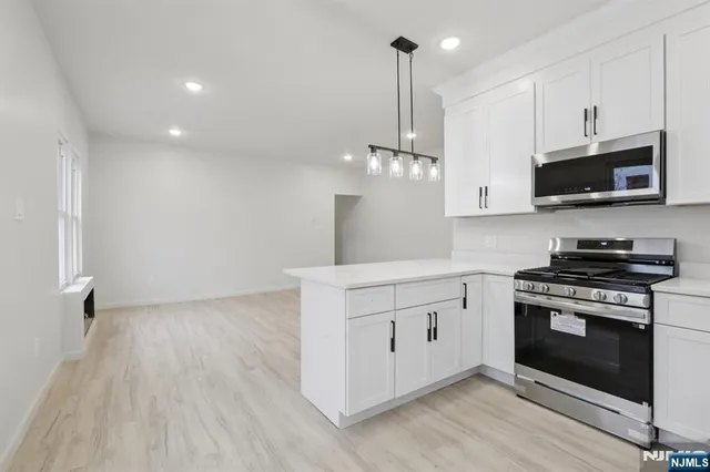 a kitchen with stainless steel appliances a stove top oven a sink and cabinets