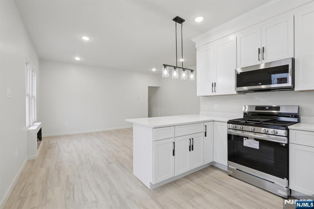 542 East 25th Street, Unit 540 Paterson, NJ 07514 - Photo 5 of 11 a kitchen with stainless steel appliances a stove top oven a sink and cabinets