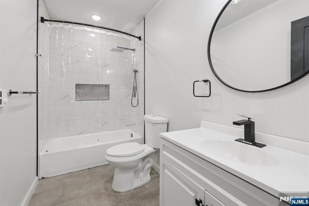 542 East 25th Street, Unit 540 Paterson, NJ 07514 - Photo 6 of 11 a bathroom with a sink a toilet and a mirror