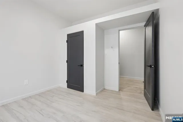 a view of an empty room with closet and a window