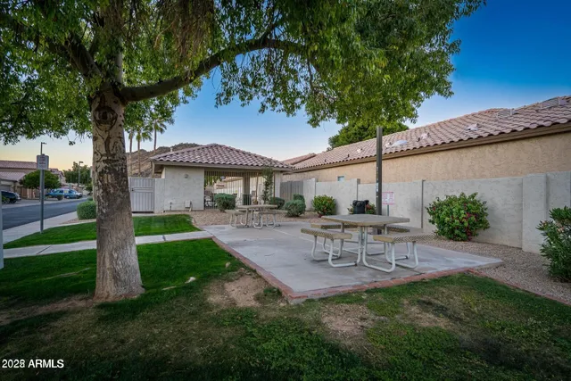 a view of a patio with a table and chairs under an umbrella