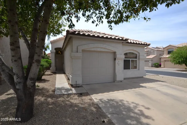 a white house with a tree in front of it